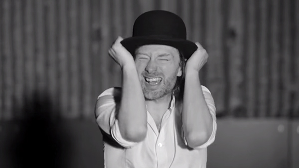 Screenshots, "Lotus Flower." Yorke takes a break from his spasms to remove his hat.