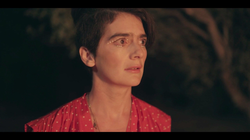 Ali (Gaby Hoffman) enters the fire scene, eyes bloodshot and adorned with white paint. Screenshot taken by the author.
